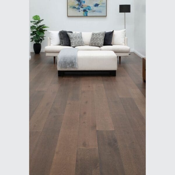 A living room with hardwood floors and white furniture.