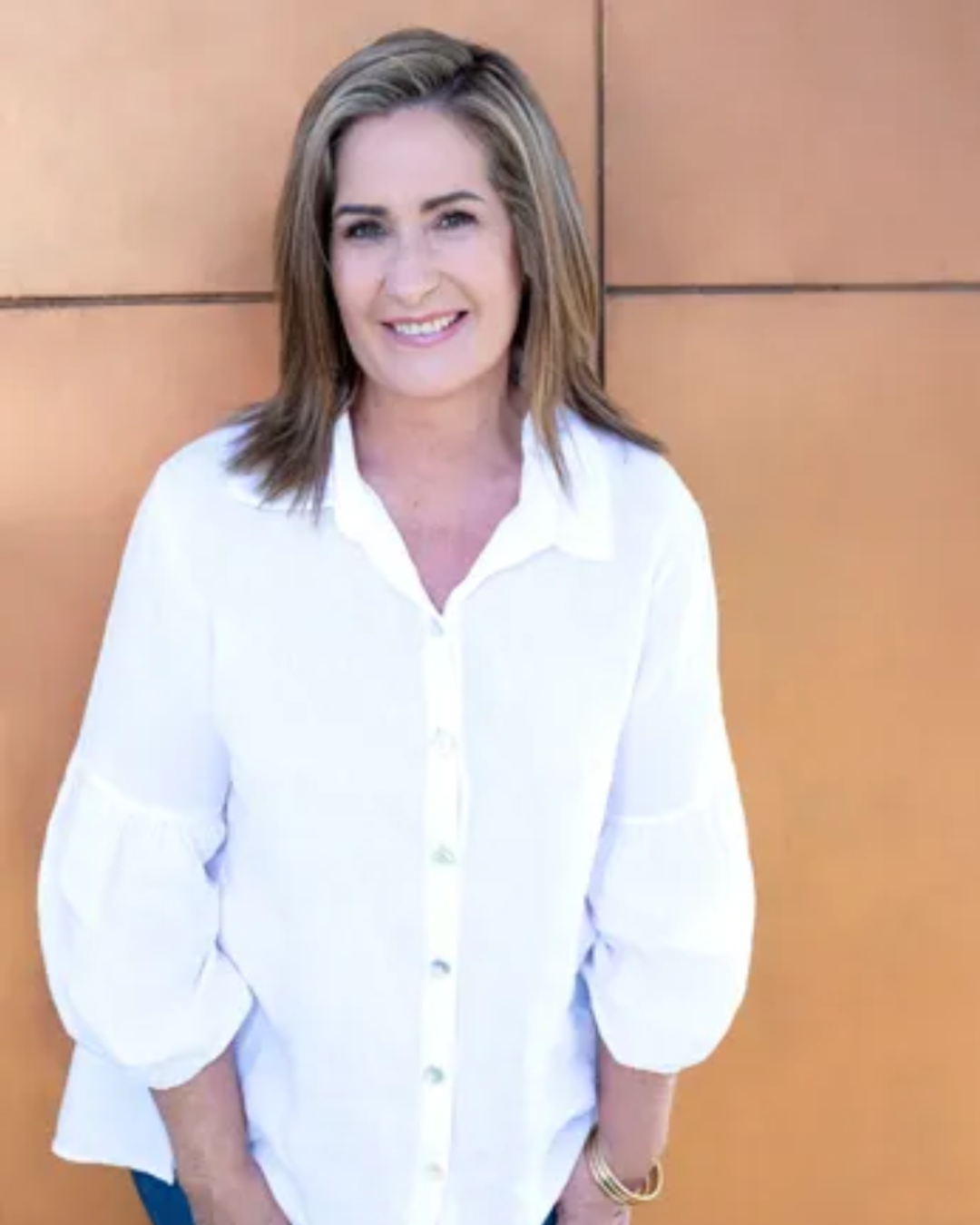 A woman standing in front of a wall.