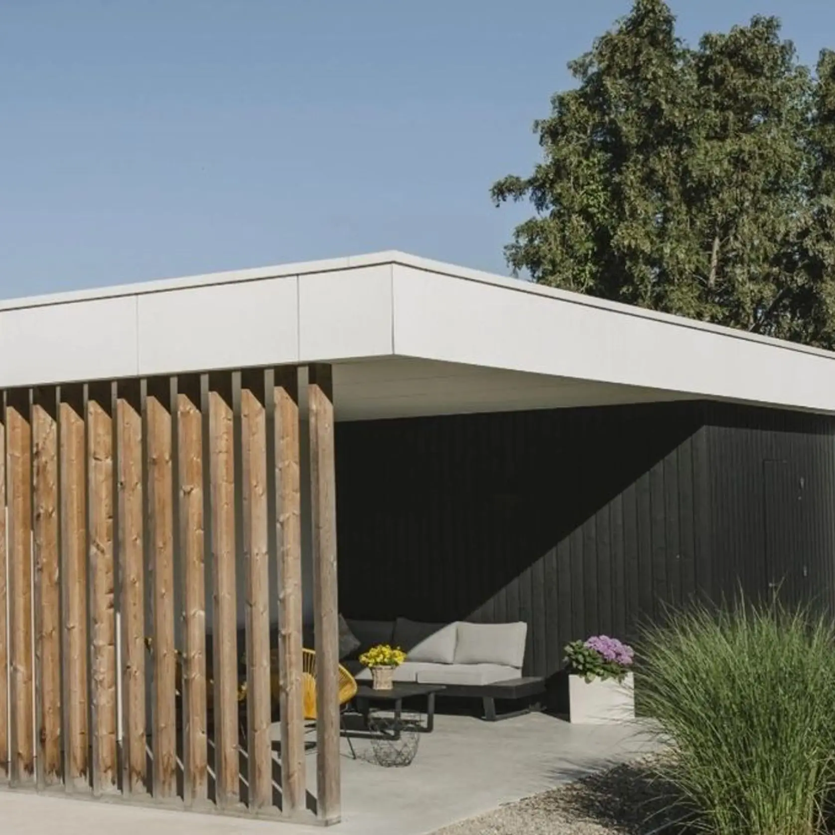 A house with a large open porch and wooden slats.