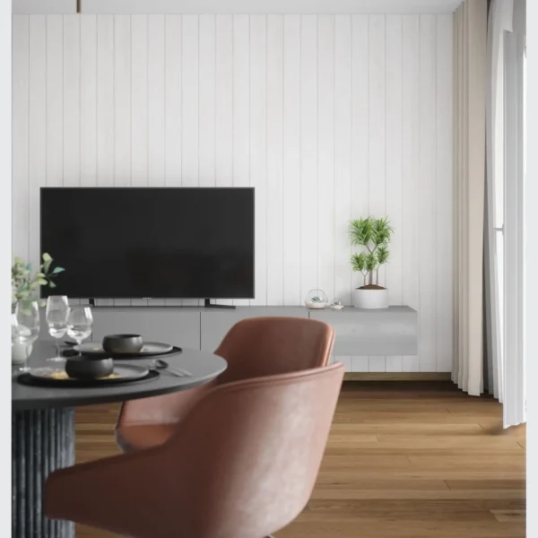 A room with a table and chairs, tv on the wall