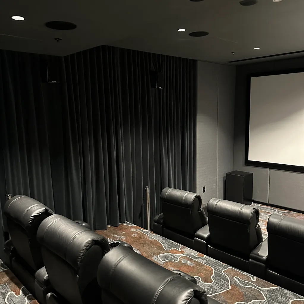 A room with a large screen and leather seats.