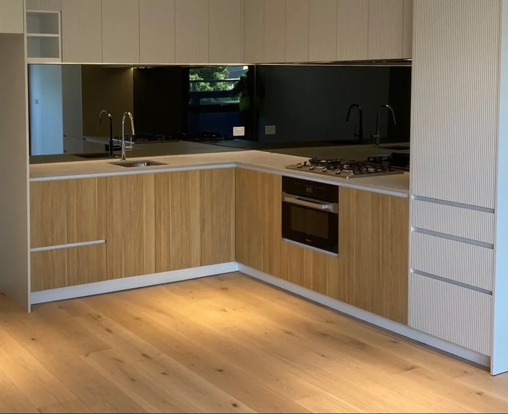 A kitchen with wooden floors and white cabinets.