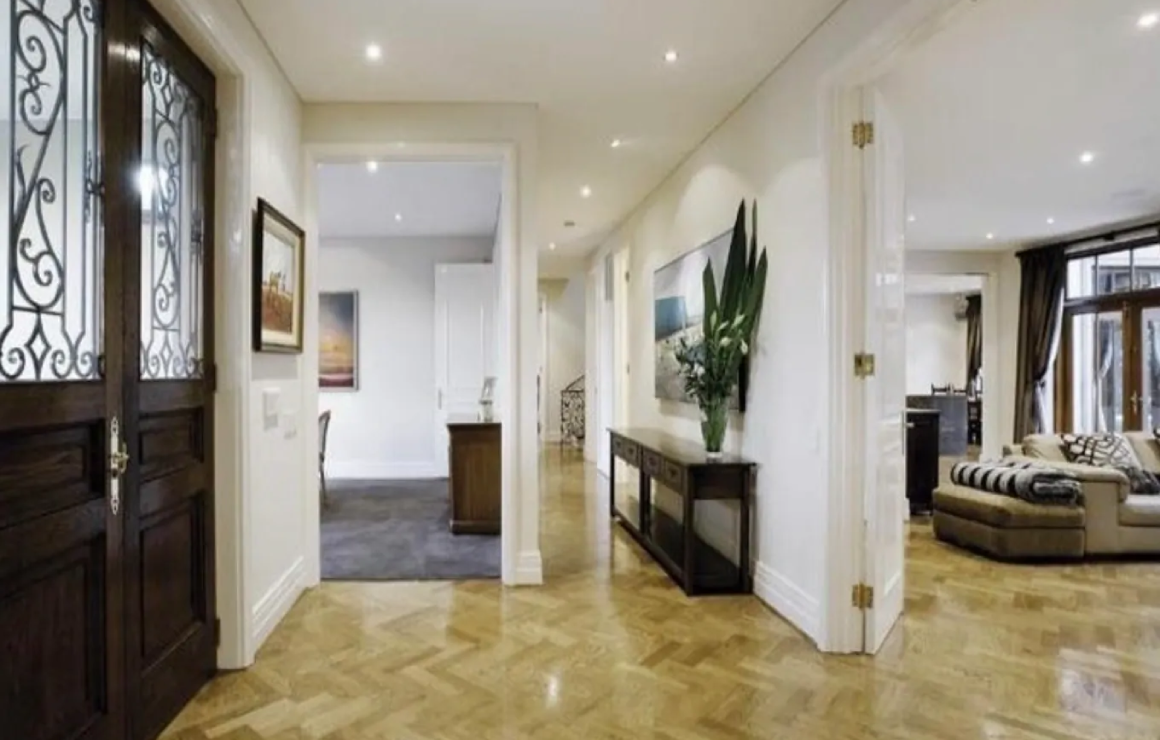 A hallway with a plant and a table in it.