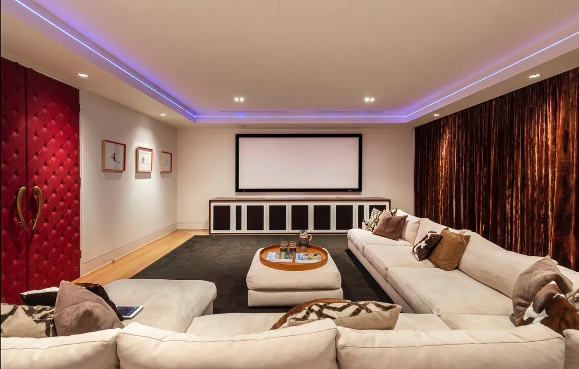 A living room with couches and a large screen tv.