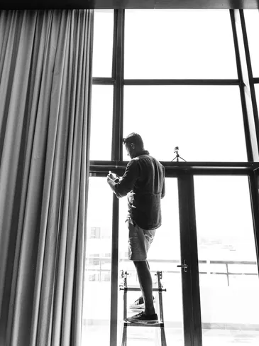 A man standing in front of a window.