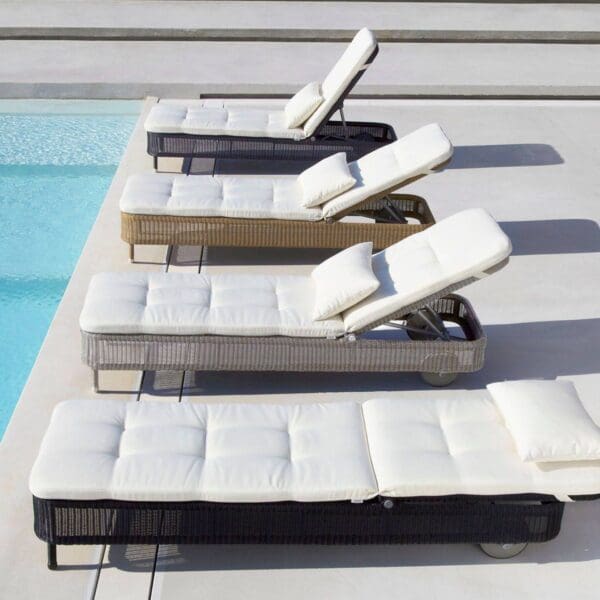 A row of lounge chairs next to the pool.