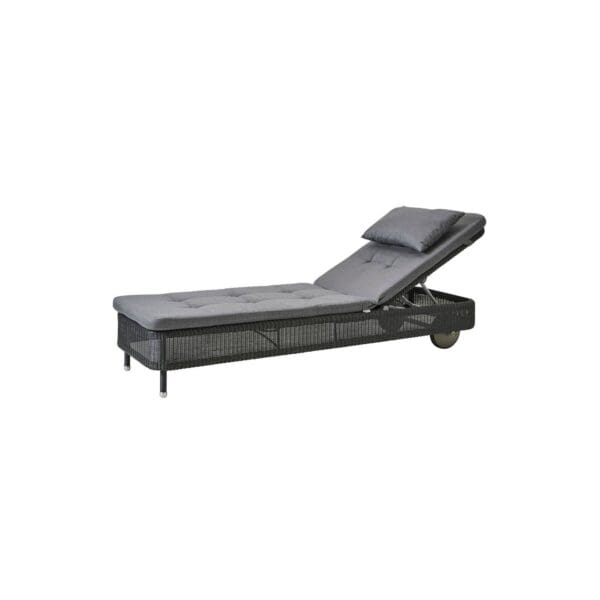 A black lounge chair with grey cushion on top of it.