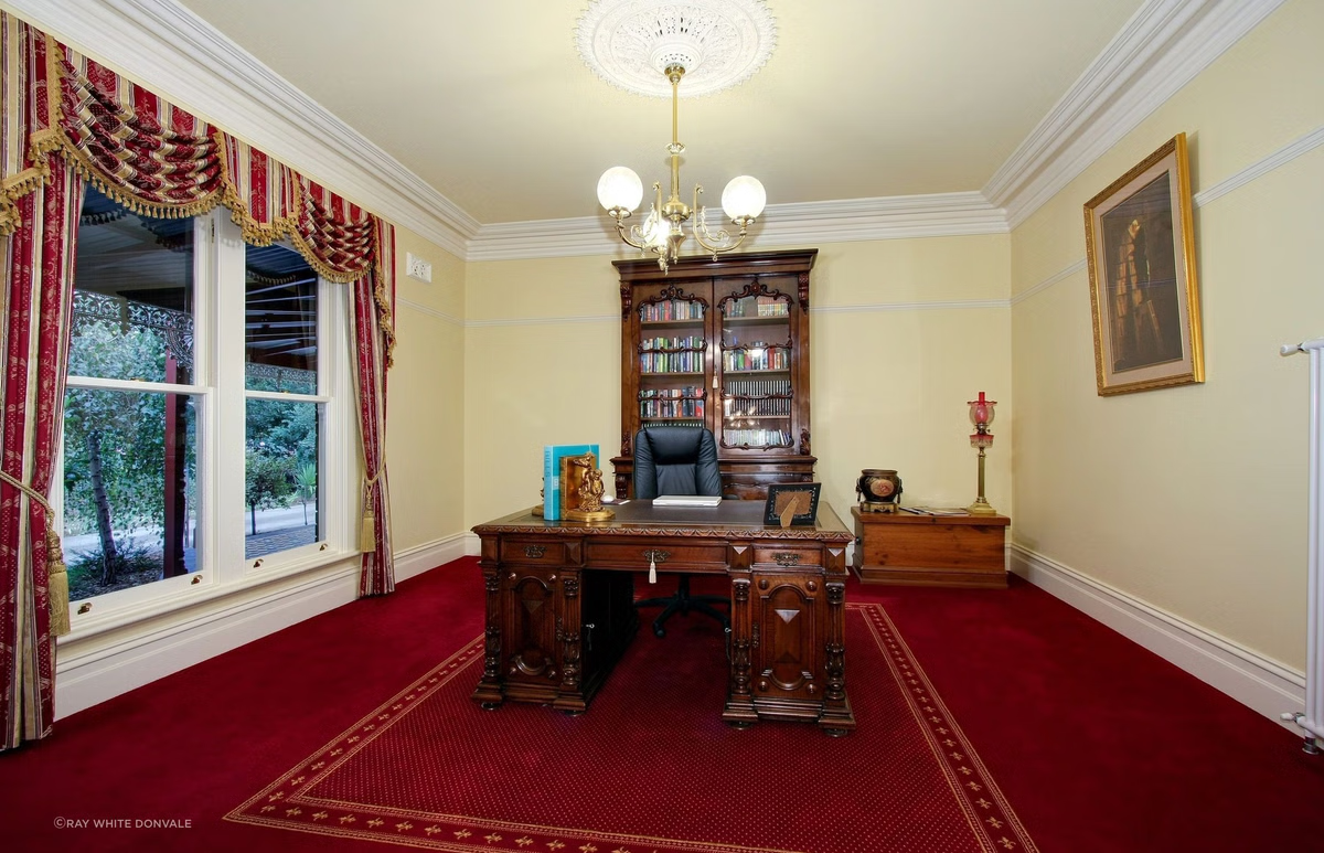 A room with red carpet and a desk