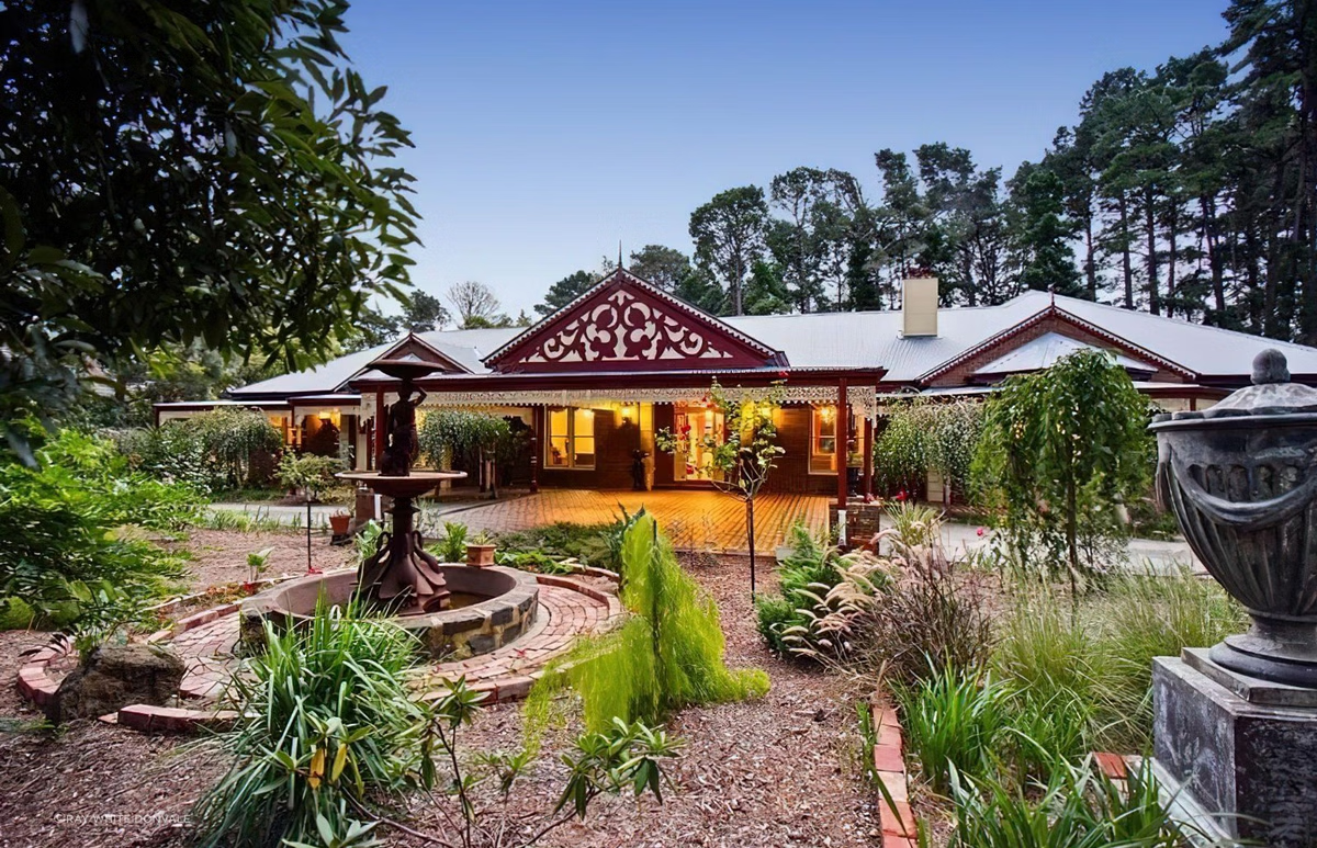 A large house with a fountain in the middle of it