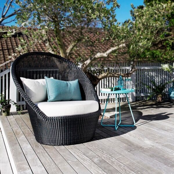 A chair and table on the deck of a house.