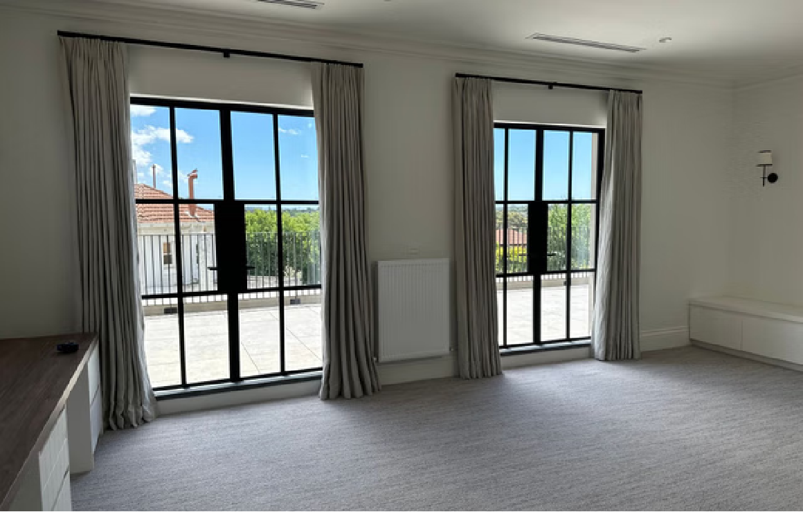 A room with two large windows and a white floor.