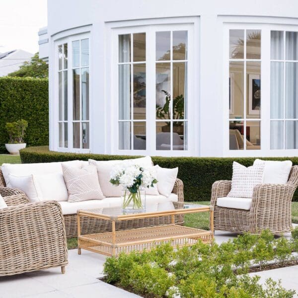 A patio with furniture and plants outside of a house.