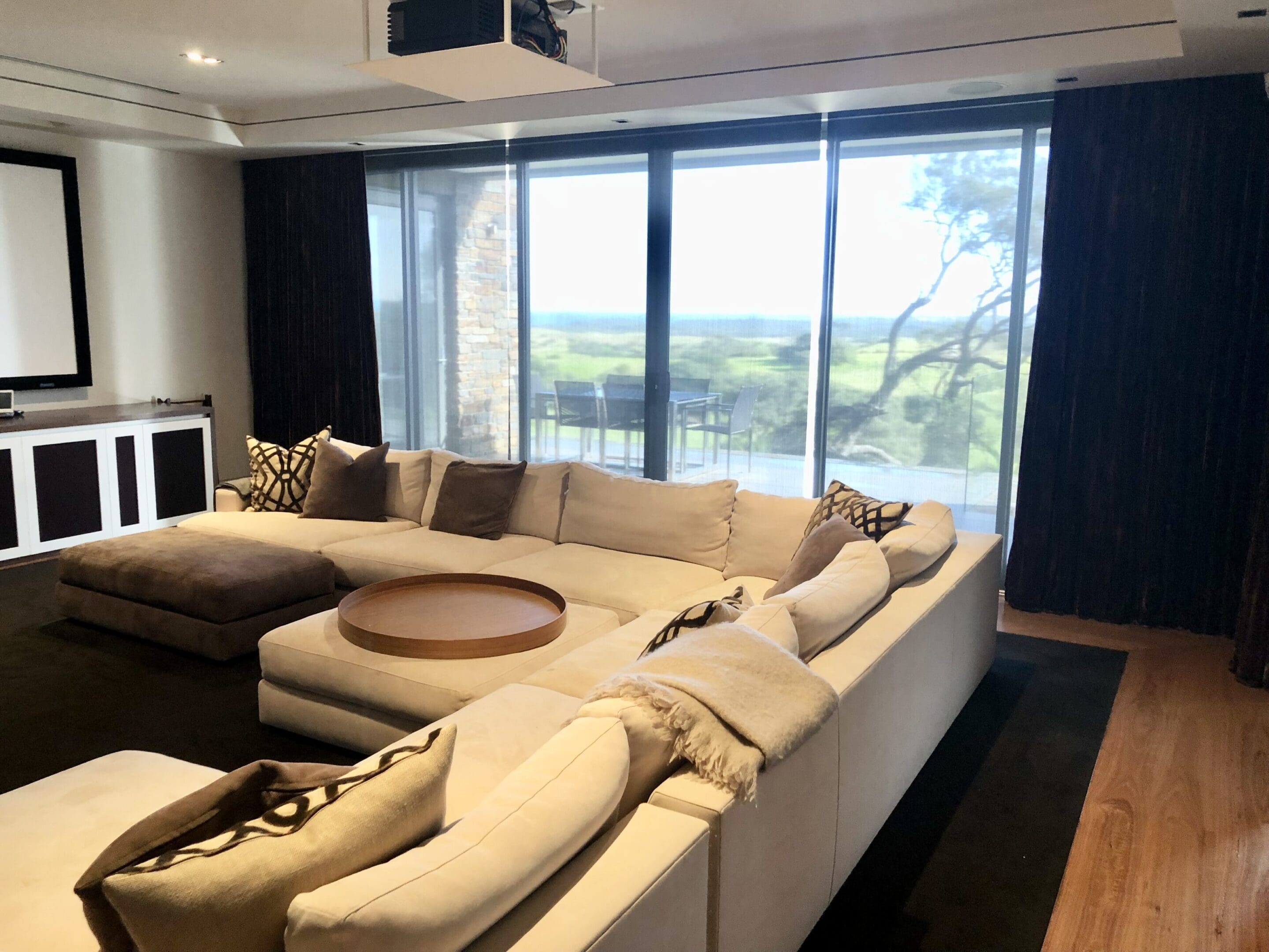 A large white sectional couch in front of a window.