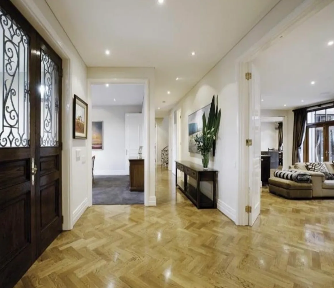 A hallway with wooden floors and white walls.