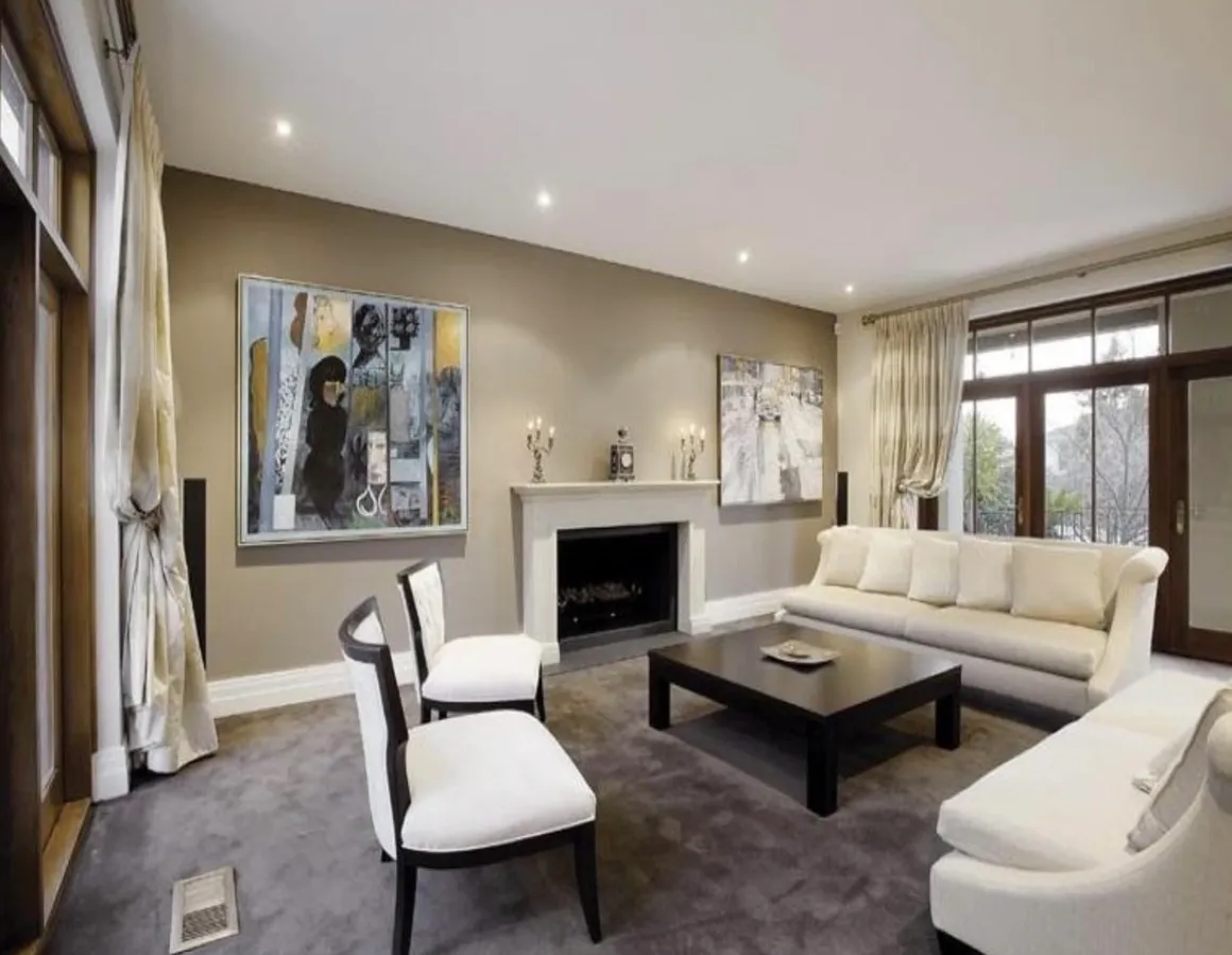 A living room with white furniture and a fireplace.