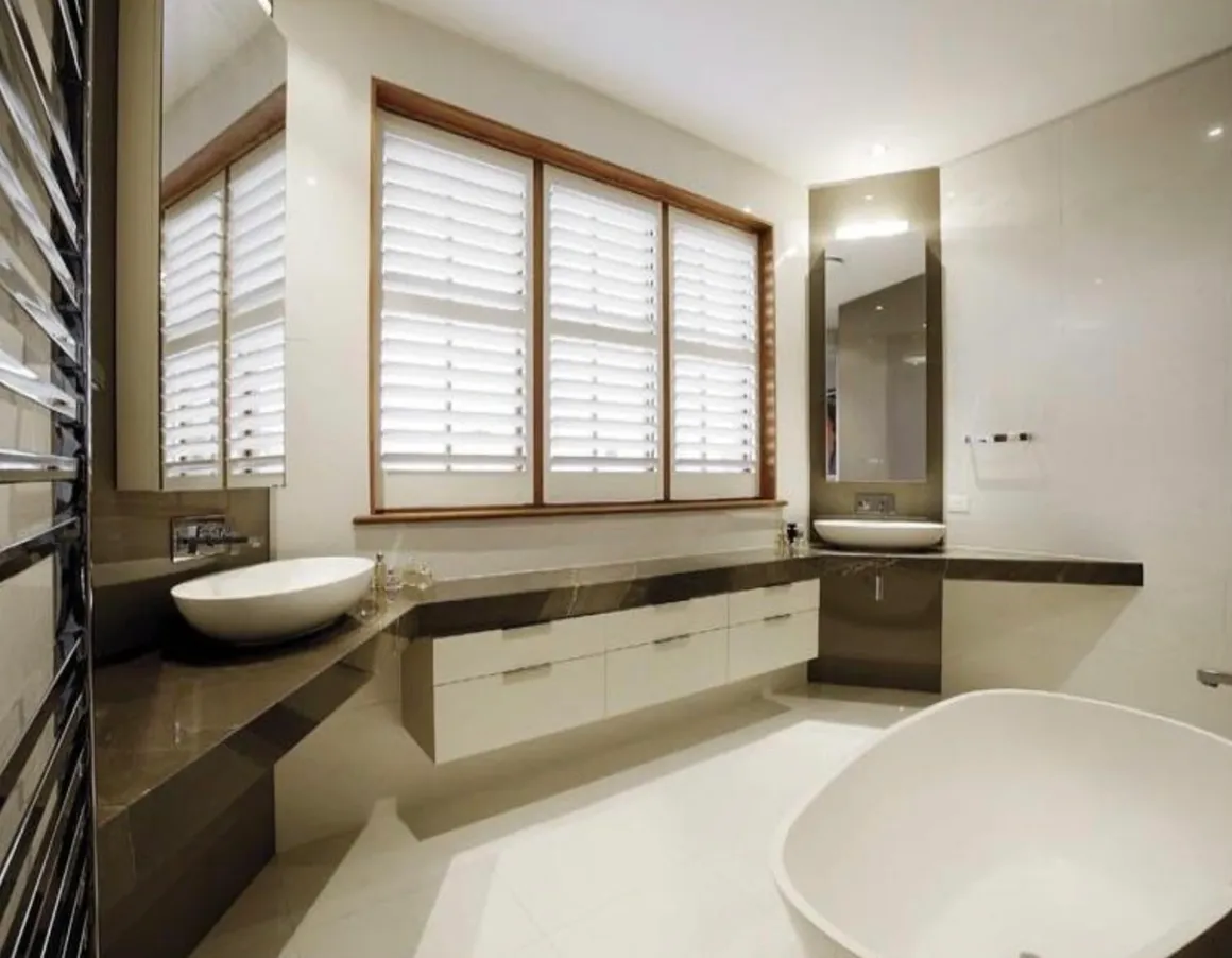 A bathroom with two sinks and a large mirror.